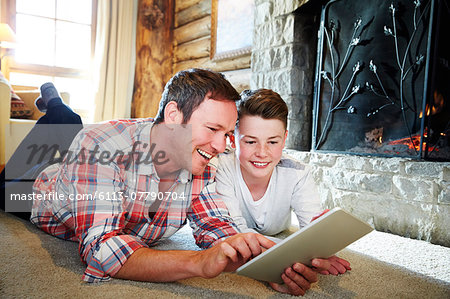 Father and son playing with digital tablet together