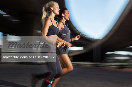 Women running together through city streets
