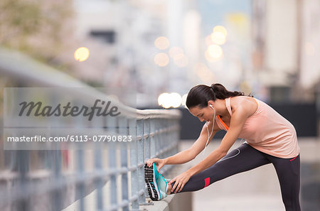 Woman stretching before exercising on city street