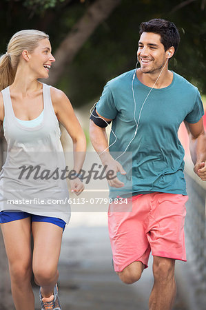 Couple running through city streets together Couple running through city streets together