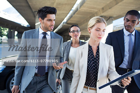 Business people walking under city overpass