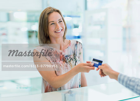 Woman paying with credit card in drugstore