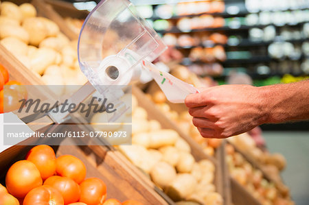 Close up of man taking plastic bag in produce section of grocery store