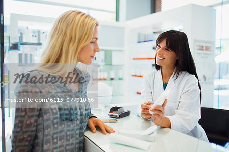 Woman discussing product with pharmacist in drugstore