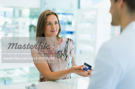 Woman paying with credit card in drugstore Woman paying with credit card in drugstore