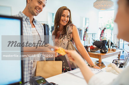 Couple paying with credit card in clothing store