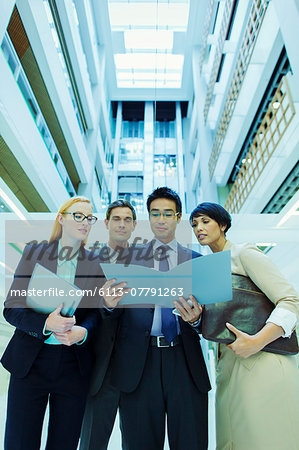 Business people looking at file in office building