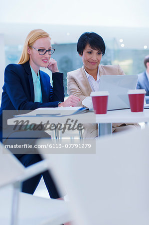 Businesswomen working on laptop at table
