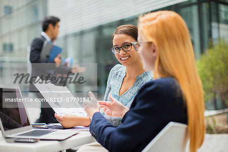 Businesswomen looking at documents at table in office building