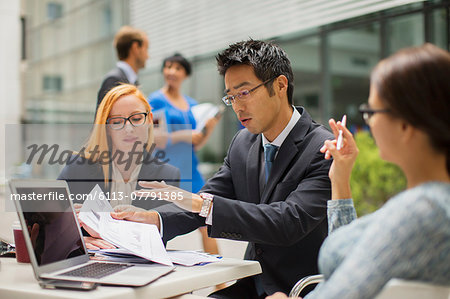 Business people talking at table outside of office building