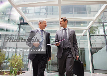 Businessmen walking out of office building together