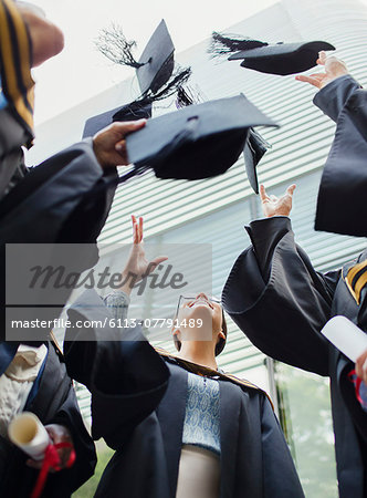 Students in gowns throwing caps in the air