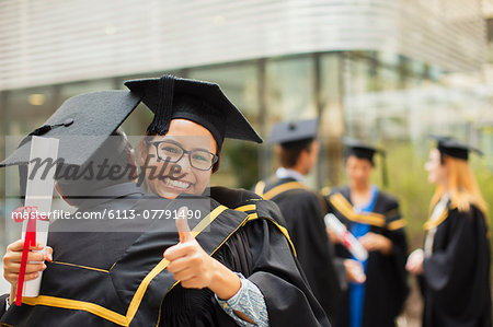 Students in cap and gown hugging