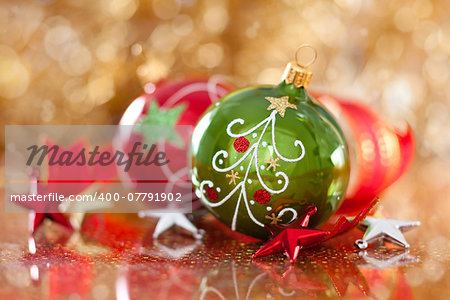 Christmas decoration with green and red balls against de-focused holiday lights.