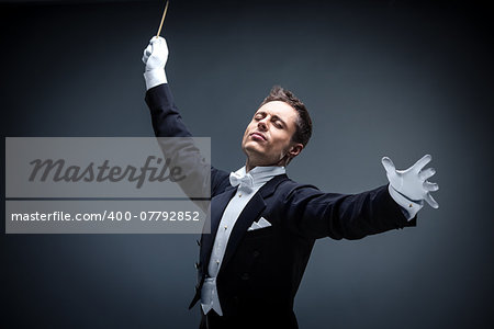 Emotional conductor in a tuxedo on a dark background