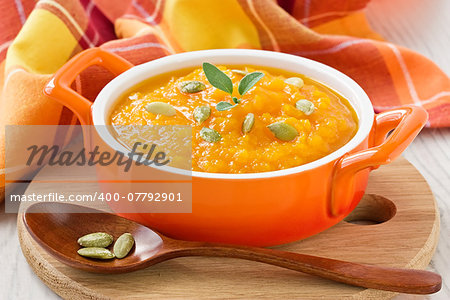 Pumpkin soup with seeds and honey in ceramic bowl