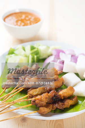 Delicious chicken satay on wooden dining table, one of famous Malaysian local dishes.