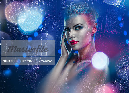 Beautiful woman with creative bright make-up over glowing lights background