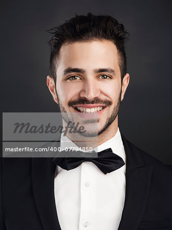 Studio portrait of a handsome young man with a suit and smiling