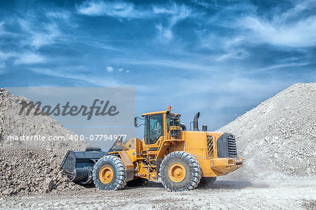 Wheel loader excavator with backhoe unloading clay