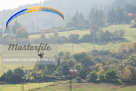 Paraglider flying dangerously low over high voltage pylons and wiring before he lands.