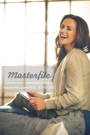 Portrait of smiling young woman using tablet pc in loft apartment