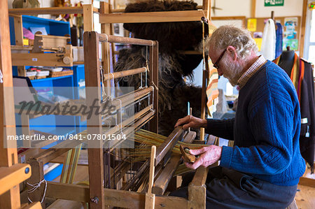 Craftsman using traditional loom to weave wool into handmade scarf at Croft Wools and Weavers, Applecross in the Highlands of Scotland, United Kingdom, Europe