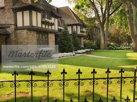 View of iron fence and house exterior in summer, Toronto, Ontario, Canada