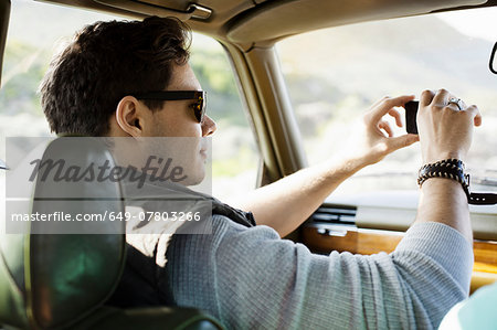 Young man photographing through windscreen, Cape Town, Western Cape, South Africa