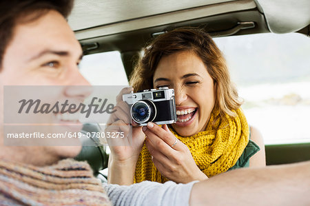 Young woman photographing boyfriend whilst driving, Cape Town, Western Cape, South Africa