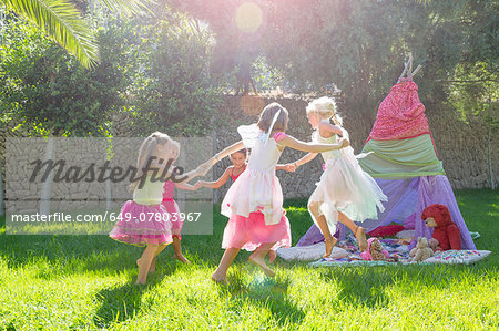 Five girls in fairy costume playing in garden