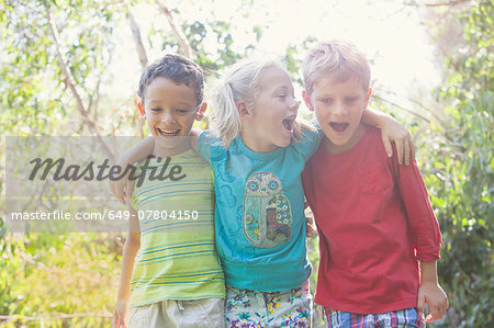 Three children in garden with arms around each other