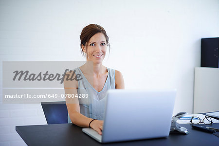 Portrait mid adult woman working from home on laptop