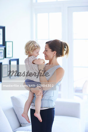 Mid adult woman and toddler daughter in living room