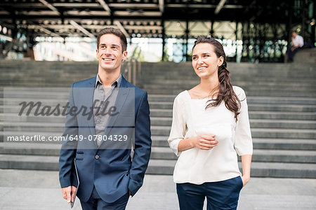 Young businesswoman and man chatting whilst walking, London, UK