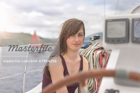Young woman relaxing on yacht, looking away