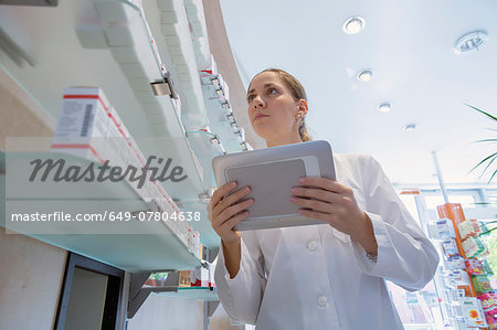Pharmacist in pharmacy holding digital tablet
