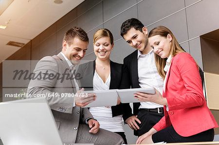 Businessmen and businesswomen sharing information on digital tablet