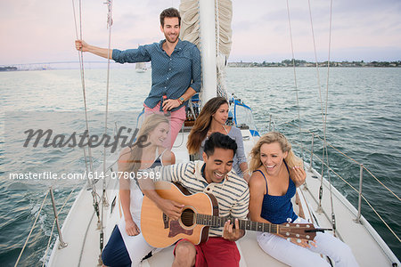 Friends on sailing boat, man playing guitar