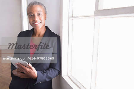 Mature woman holding digital tablet, portrait