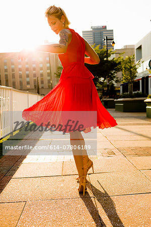 Young woman twirling whilst wearing red dress Young woman twirling whilst wearing red dress