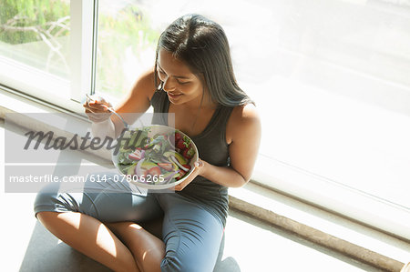 Woman eating salad at home