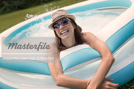 Mature woman in paddling pool, splashing water