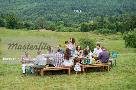 Family having meal together and socialising, outdoors