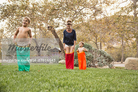 Mother and two sons having a sack race, County Park, Los Angeles, California, USA