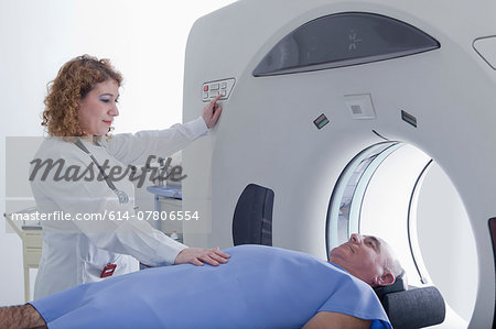 Doctor preparing patient for CT scanning