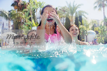 Family with two children enjoying themselves in swimming pool