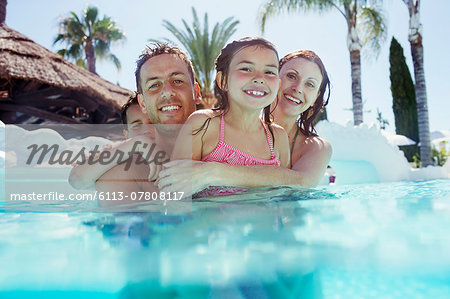 Portrait of happy family with son and daughter in swimming pool