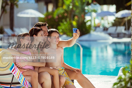 Family with two children taking selfie by swimming pool