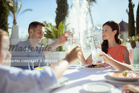 Family raising toast at table outdoors